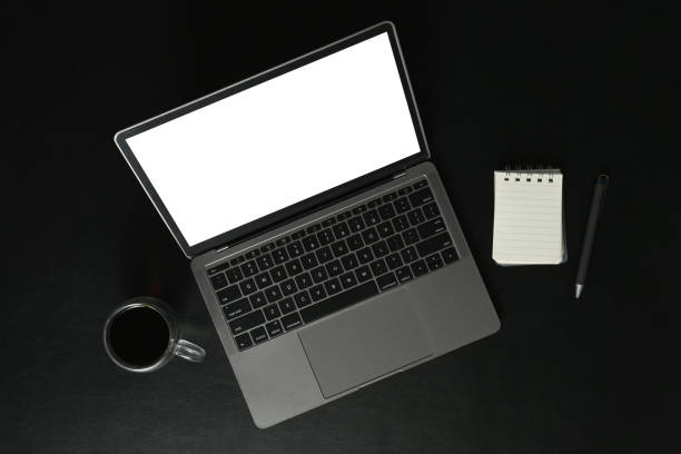 istock Above view of laptop with empty display, notepad and coffee cup on black background. 1506704873