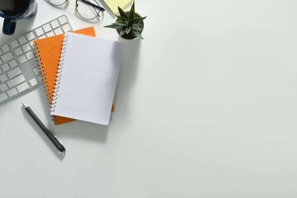 istock Top view blank notepad, glasses, coffee cup and keyboard on white office. Copy space for your text. 1506705445