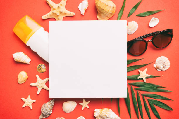 istock Summer time concept with blank greeting card and blank white paper on colored background. Seashells from ocean shore in the shape of frame separated with space for text top view 1506709894