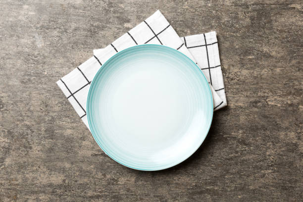 istock Top view on colored background empty round blue plate on tablecloth for food. Empty dish on napkin with space for your design 1506710420