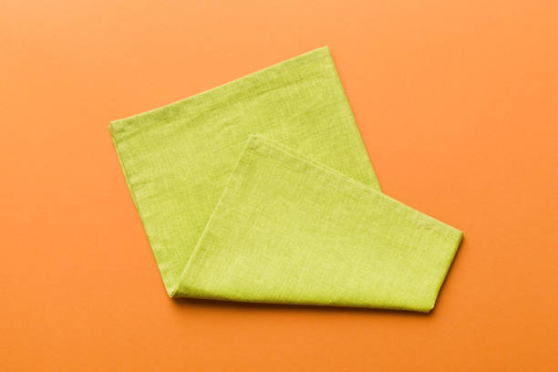 istock top view with green kitchen napkin isolated on table background. Folded cloth for mockup with copy space, Flat lay. Minimal style 1506710428