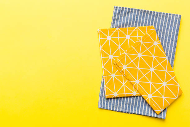 istock top view with yellow empty kitchen napkin isolated on table background. Folded cloth for mockup with copy space, Flat lay. Minimal style 1506710429