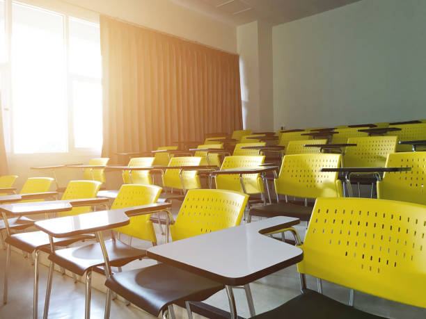 istock Classroom or lecture room empty with rising sun in morning. Many chairs installed for student in college or university. 1506729388