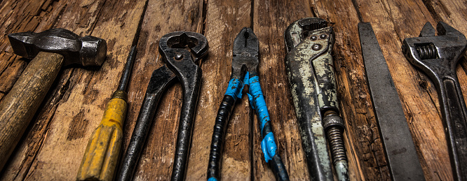 An old rusty set of hand tools on a wooden background. High quality photo