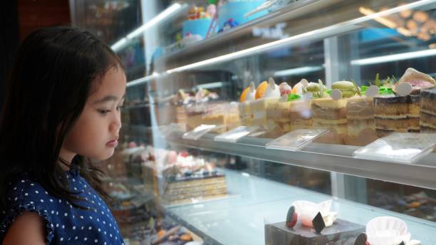 istock Asian little girl looking at cakes and sweets 1506772796