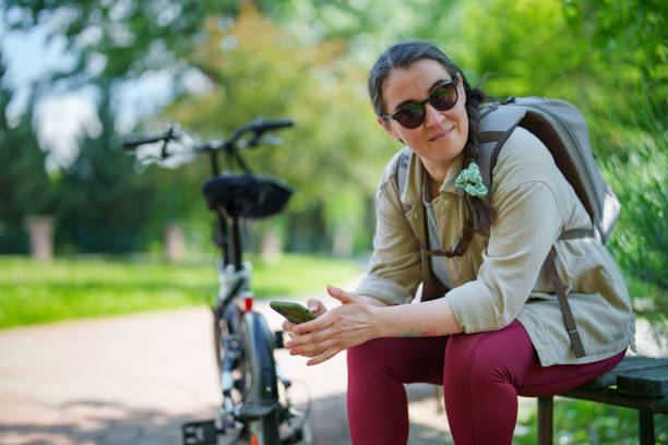 istock Female bicycle rider resting and using mobile phone 1506812529