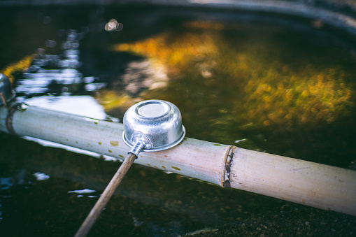 A watering place and ladle for purifying hands in a Japanese garden.