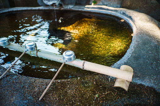 A watering place and ladle for purifying hands in a Japanese garden.