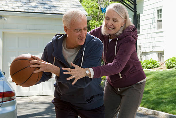 casal idoso jogar basquetebol - active seniors enjoyment driveway vitality imagens e fotografias de stock