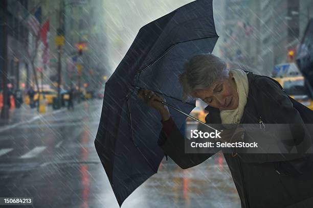 Matura Donna Con Ombrello Contro Il Vento - Fotografie stock e altre immagini di Pioggia - Pioggia, Vento, Ombrello