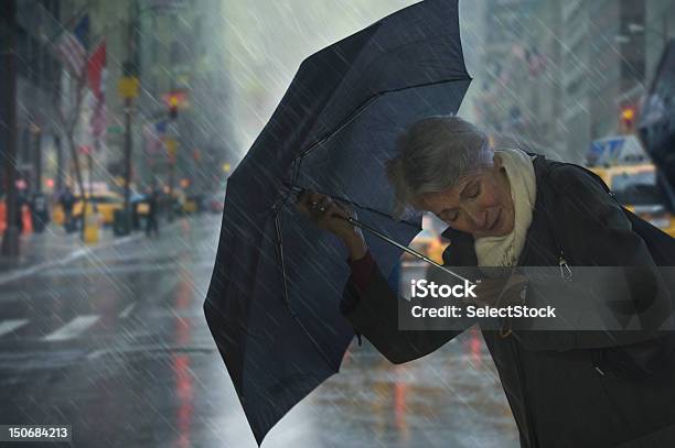 マチュアパラソルを持つ女性の風力 - 雨のストックフォトや画像を多数ご用意 - 雨, 風, 傘