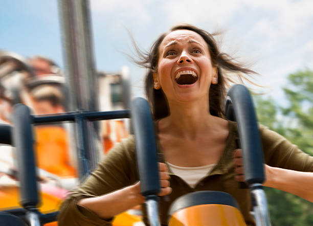 joven mujer pateando una montaña rusa - rollercoaster fotografías e imágenes de stock