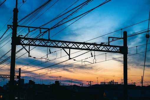 Night shot depicting interconnecting railroad tracks illuminated at night in the city at a railroad station.