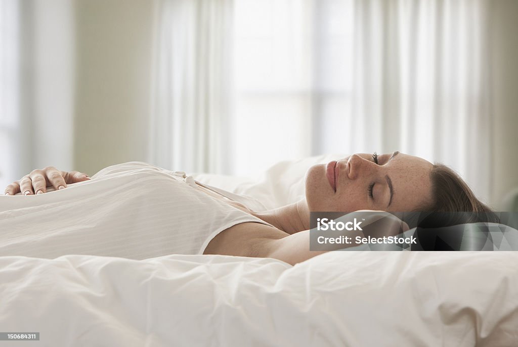 Jeune femme au lit et chambre - Photo de Dormir libre de droits