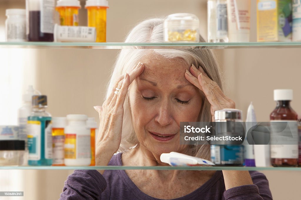 Senior Frau mit Kopfschmerzen - Lizenzfrei Badezimmerschrank Stock-Foto