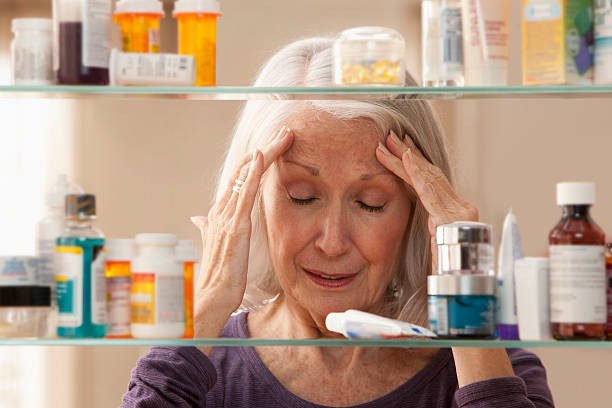 senior mujer con dolor de cabeza - aging process medicine cabinet viewpoint front view fotografías e imágenes de stock