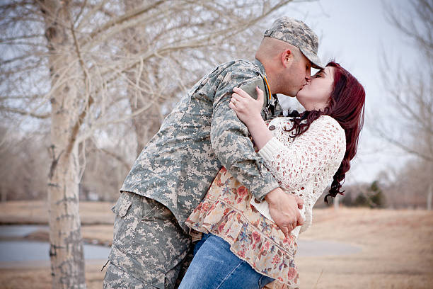 Soldier kissing his wife stock photo