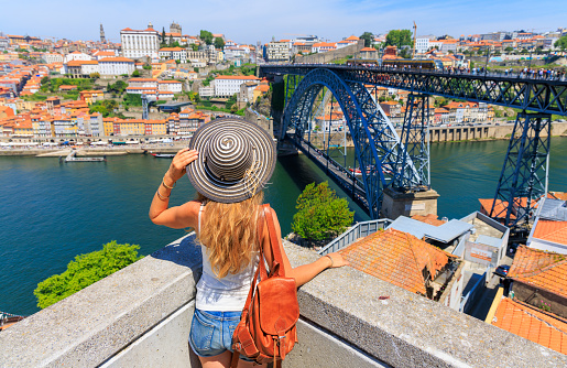 Porto travel destination- Woman  enjoying panoramic view of city landscape, famous bridge and Douro river of Oporto- Portugal