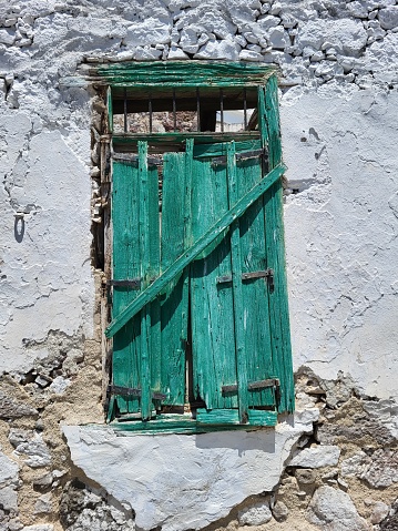Rustic white house and wooden green doors, Milos island