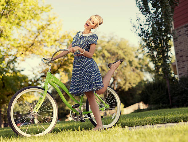 A retro female enjoys a ride on her vintage bike in the summer afternoon.