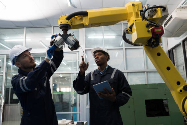 istock Teamwork of male engineer using laptop computer inspecting quality automatic robotic arm at production line in industry factory. Male technician worker checking and control automatic robot arm 1506890551
