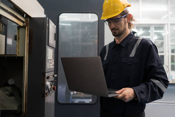 istock Male engineer worker working with laptop computer for control machine in the workshop. Male worker working with lathe machine with safety uniform and helmet in the industry factory 1506891026