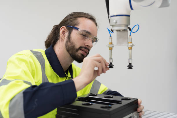 istock Automated manufacturing industries. Innovative technology. Male engineer inspecting quality of compact desktop robotic arm for for manufacturing lines in workshop. Smart automation tasks concept 1506891061
