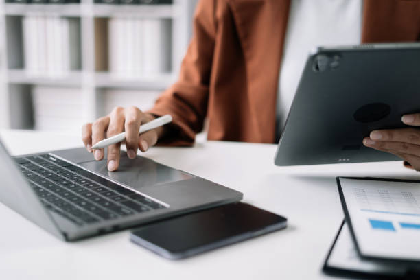 istock Businesswomen using tablet with laptop and document on desk in modern office. 1506928106