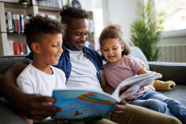 Father reading book to son and daughter. Children education and development concept