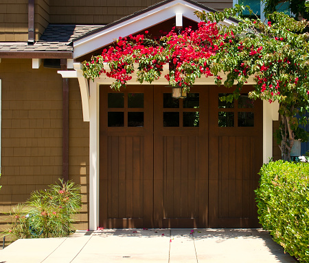 Craftsman style garage with a bougainvillea vine covered trellis