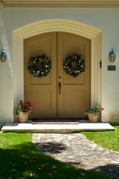 istock Sunlit footpath leads to double front door with wreaths 1506939043