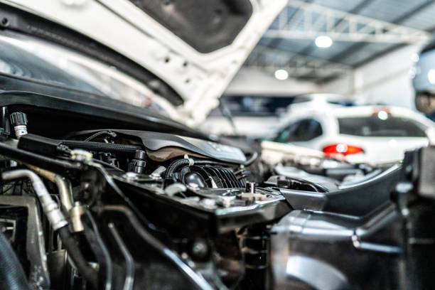 A detailed view of a classic car engine shows mechanical parts and wiring components under the hood