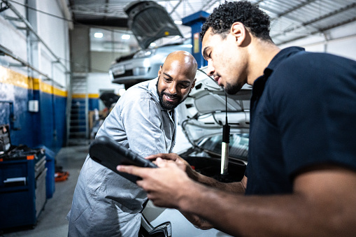 Mechanics talking while repairing a car in an auto repair shop