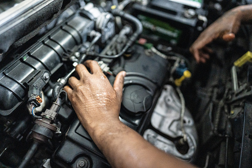 Mechanic's hands repairing a car in an auto repair shop