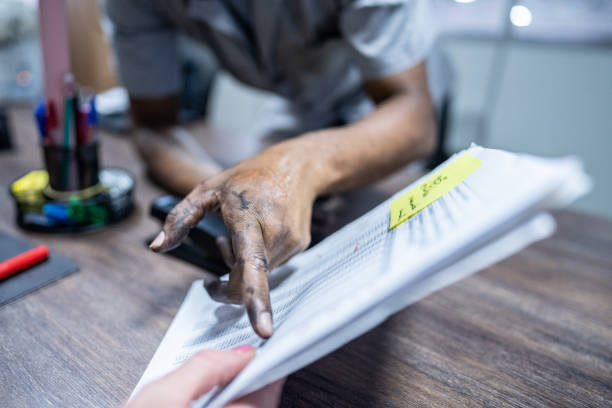 Man's hand pointing to something on the paper in the office