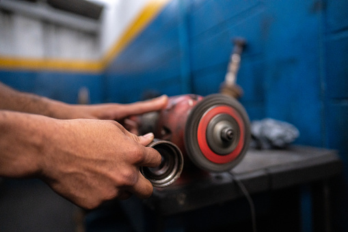 Mechanic's hands working on a machine in an auto repair shop