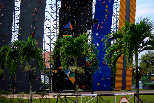 A military man or airsoft player in a camouflage suit sneaking the rope bridge and aims from a sniper rifle to the side or to target.