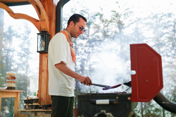 istock Man cooking sausage on bbq grill, weekend activities at the backyard 1506996788