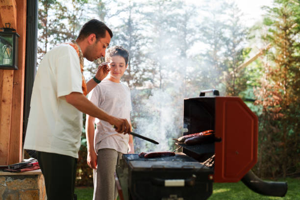 istock Father and son cooking on bbq grill, weekend activities at the backyard 1507000583