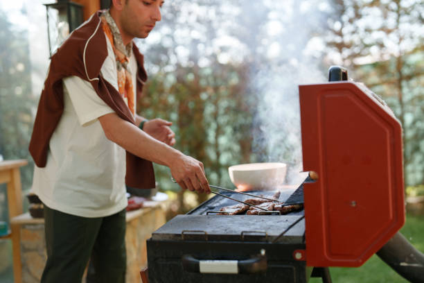istock Man cooking sausage on bbq grill, weekend activities at the backyard 1507003842