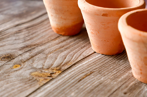 set of small clay pots on a brown background