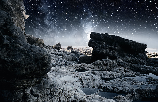 Barren landscape dominated by a majestic rock formation that stands as a monolithic sentinel. The sky above is cast in darkness, adorned with distant stars that twinkle against the void. The scene evokes a sense of somberness and mystery, reminiscent of a sci-fi or fantastical realm. The desolate surroundings and otherworldly ambiance create an eerie atmosphere, drawing viewers into a world both familiar and alien. The isolation and drama within this surreal panorama leave us captivated, pondering the secrets that lie hidden within this enigmatic expanse. PHOTOMONTAGE WITH DIGITAL ELEMENTS