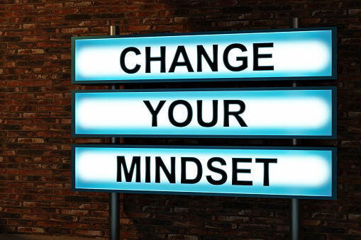 Change your mindset. Black letters on a blue illumintaed light box, red brick wall. Advice, attitude, change, progress, encouragement, opportunity. 3D illustration