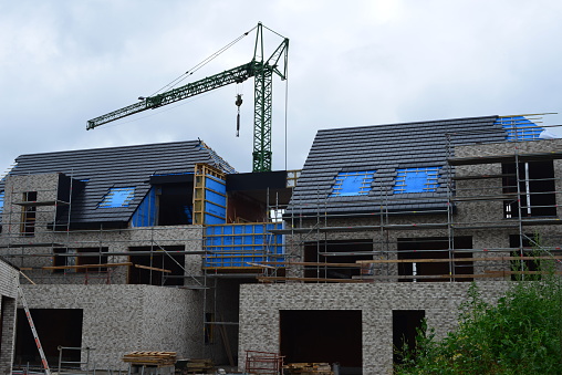Leuven, Vlaams-Brabant, Belgium - July 1, 2023: apartment complex structural works nearly finished. Black Rockpanels covering the roof gutter and side walls roof