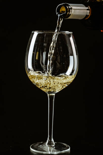 istock White wine being poured in a wine glass on a dark background 1507104637