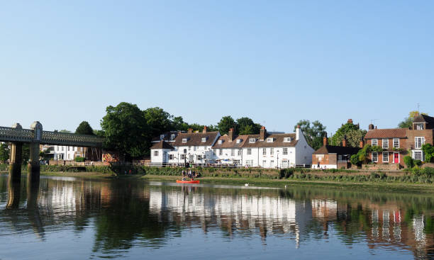 tranquilla scena serale sul tamigi con una canoa rossa che passa un pub imbiancato - chiswick foto e immagini stock