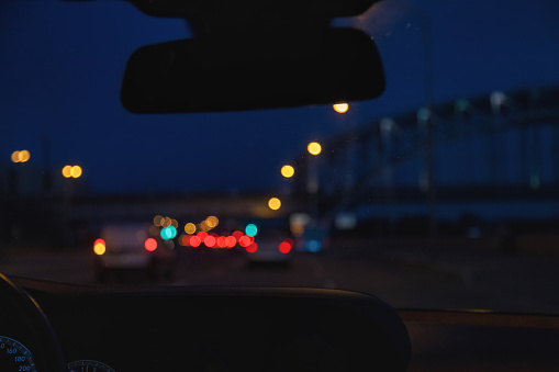 Car windshield view on New York night highway with car and street lamps. Abstract stylish urban backgrounds for design concept. Defocused lights city, style color tone. Copy ad text space, wallpaper