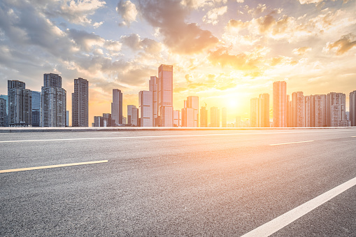 Empty asphalt road and city buildings skyline. Urban road transport scene