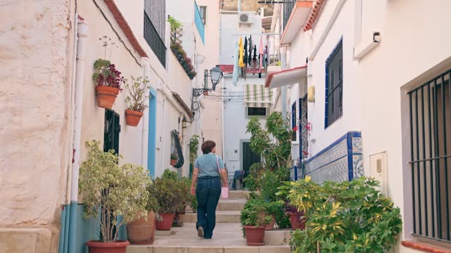 Woman walks through the streets of the Santa Cruz neighborhood in Alicante.