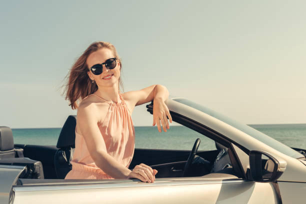 istock Young woman drive a car on the beach 1507204452
